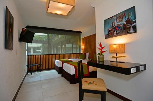 a bedroom with a bed and a desk in a room at Auténtico Hotel in San José