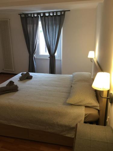 a bedroom with a large bed and a window at Albergo Ristorante Belcantone in Novaggio