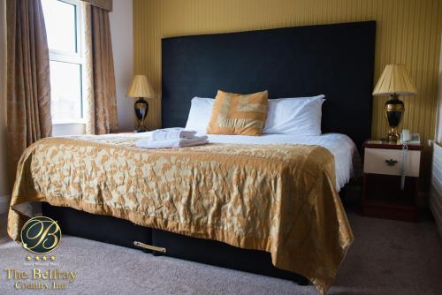 a bedroom with a large bed with a black headboard at The Belfray Country Inn in Derry Londonderry