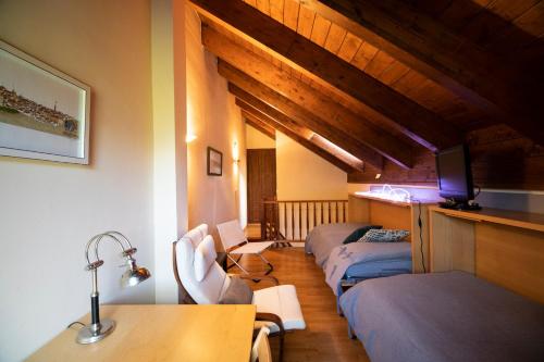 a room with three beds and a table and chairs at Inmocyma Abetal grandes vistas, con piscina-Linsoles- Benasque in Benasque