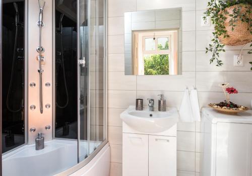 bagno bianco con doccia e lavandino di Cracow Best Location Apartment with Garden by Cozyplace a Cracovia