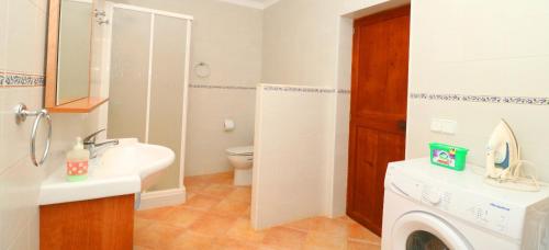 a bathroom with a sink and a washing machine at Can Crestall in Campos