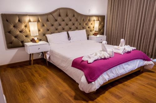 1 dormitorio con 1 cama grande y cabecero grande en La Ensenada Hotel Chachapoyas, en Chachapoyas
