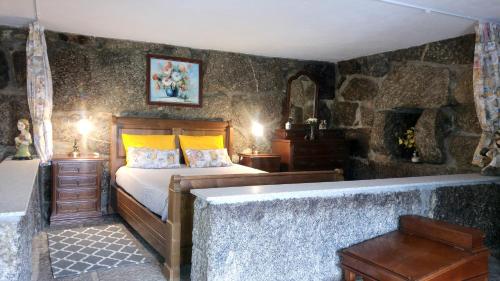 a bedroom with a bed and a bath tub at Casa do Lagar in Resende