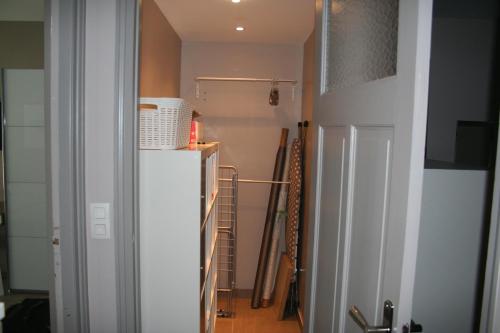Cette chambre dispose d'un couloir avec un réfrigérateur blanc. dans l'établissement Appt Hotel republique, à Lille