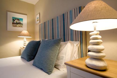 a bedroom with a bed with a lamp and pillows at The Old Custom House in Padstow