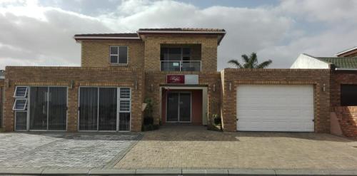 a brick house with a white garage door at Beulahland Guesthouse in Kuilsrivier