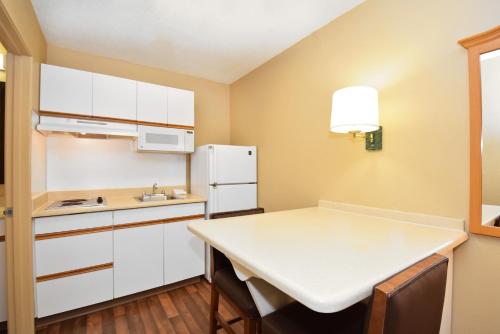 a small kitchen with a table and a refrigerator at Extended Stay America Suites - Seattle - Southcenter in Tukwila