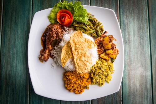 a plate of food with rice and vegetables on a table at Lazy Koala in Hikkaduwa