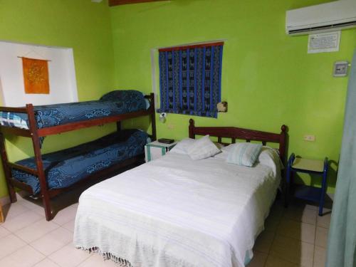 a bedroom with a white bed and green walls at Nicolas Nancy Ricardo in Las Grutas