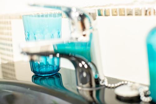a blue glass is sitting on the edge of a sink at Lima waikiki beach in Corralejo