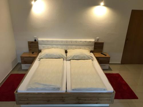 two beds in a room with two lights on the wall at Gästehaus Blümel in Köflach