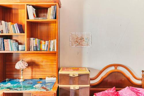ein Schlafzimmer mit einem Bett und einem Bücherregal mit Büchern in der Unterkunft Tetouan house in Tétouan