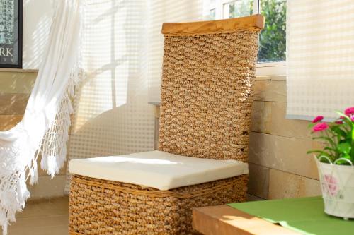 une chaise rembourrée assise sur une terrasse couverte avec une fenêtre dans l'établissement Lima waikiki beach, à Corralejo