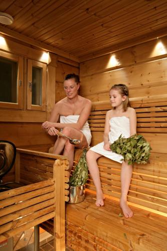 a man and a woman sitting in a sauna at Ounasvaaran Lakituvat Chalets in Rovaniemi