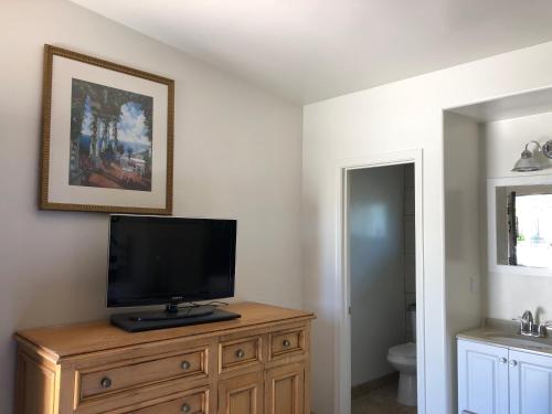 a television on a wooden dresser in a bathroom at Casa Del Sol in Carpinteria