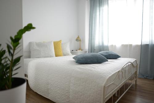 ソスノヴィエツにあるApartamenty Europaのベッドルーム(白いベッド、青い枕付)