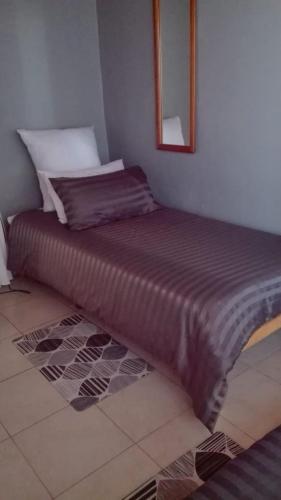 a large bed in a room with a mirror at Beulahland Guesthouse in Kuilsrivier