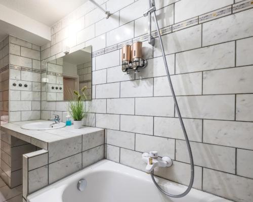 a bathroom with a tub and a sink and a shower at Basement Apartment in Cologne