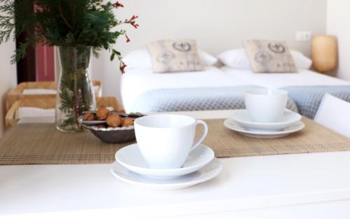 two cups and saucers on a table in a bedroom at Apartamentos Plaza Mayor in Gijón