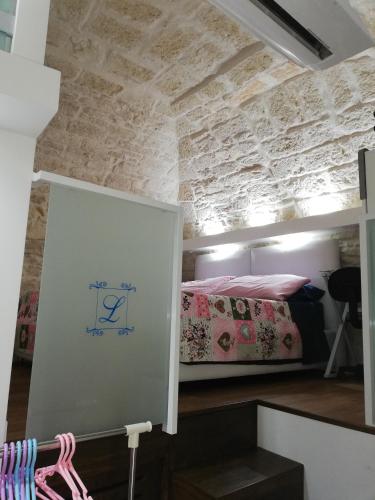 a room with two beds in a room with a stone wall at Lilla B&B in Molfetta