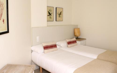 two beds in a room with white walls at Apartamentos Plaza Mayor in Gijón