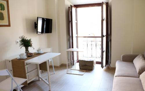 a living room with a couch and a table at Apartamentos Plaza Mayor in Gijón