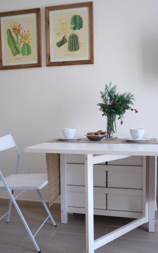 a white table with a vase on it next to a chair at Apartamentos Plaza Mayor in Gijón