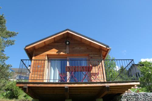 a tree house with a balcony and two chairs at Clos Shambhala-Chalet d'hôtes in Saint-Jean-Saint-Nicolas