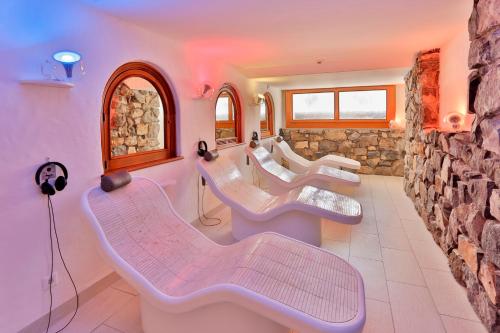 a row of sinks in a room with a stone wall at ERMITAGE Wellness- & Spa-Hotel in Gstaad