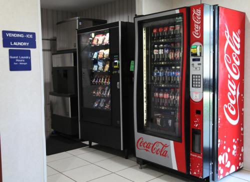 two soda machines in a store with drinks in them at Ramada by Wyndham Bloomington I-55 and I-74 IL in Bloomington