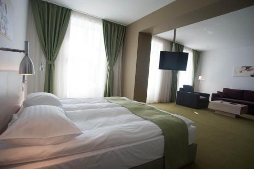 a bedroom with a large bed and a living room at Hotel Armatti in Braşov