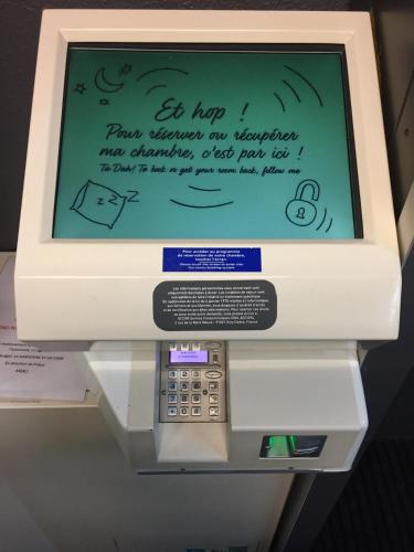 an atm machine with a screen with writing on it at IBIS Budget Aix en Provence Est Le Canet in Meyreuil