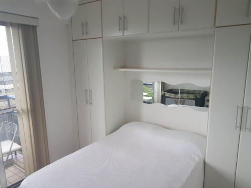 Habitación blanca con cama y ventana en O melhor em Brasília - Sudoeste - Ville de France, en Brasilia