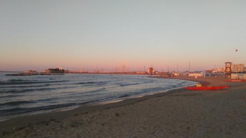 a beach with a red boat on the sand at Hotel Prestige in Rimini