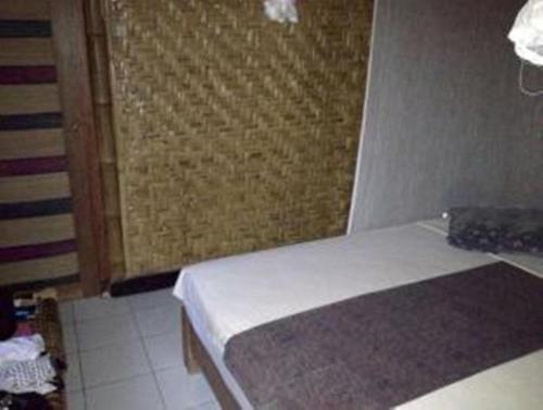 a small bedroom with two beds and a window at Little Woodstock Homestay in Gili Trawangan