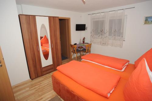 Sala de estar con 2 camas y mesa en Gasthaus-Pension Fischerkeller, en Randegg