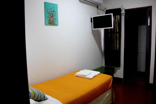 a room with a bed and a tv on the wall at Hotel Vuelta del Ombu in Gobernador Ingeniero Valentín Virasoro