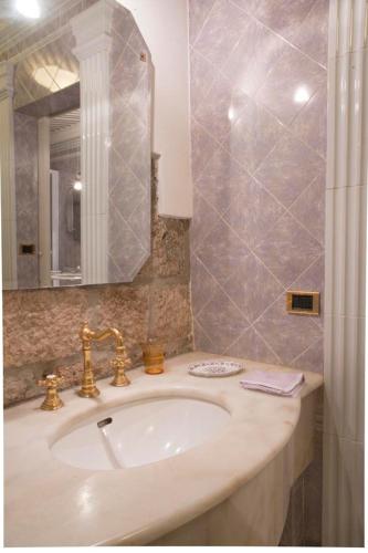un baño con lavabo y espejo en Luxory suite su Lungarno, en Pisa