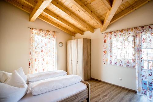 Schlafzimmer mit einem Bett und einem Fenster mit Vorhängen in der Unterkunft Breitenhof - Haus Breiten in Angath