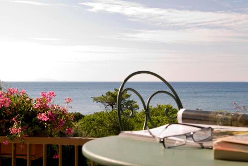 a table with a view of the ocean with a telescope at Roccamare Resort - Casa di Ponente in Castiglione della Pescaia