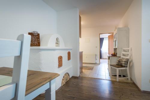 eine Küche und ein Wohnzimmer mit einem Kamin und einem Tisch in der Unterkunft Ninas Residenzerl in Kolsassberg