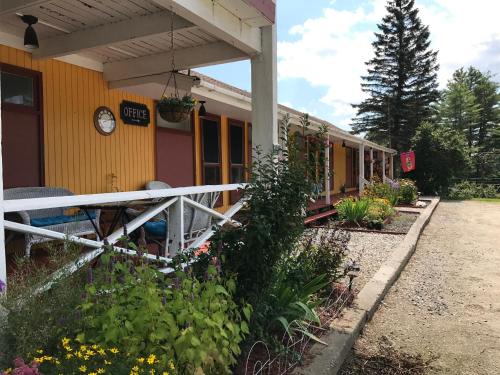 a yellow house with a clock on the side of it at Snowdon Chalet Motel in Londonderry