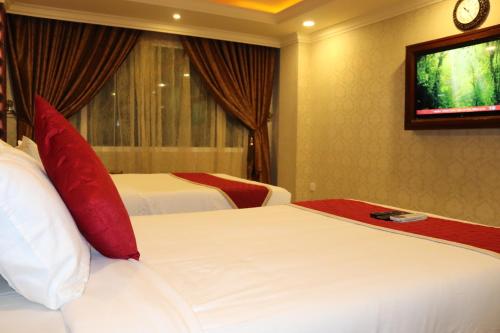 a hotel room with two beds and a television at Hyders Park The Business Hotel in Thanjāvūr
