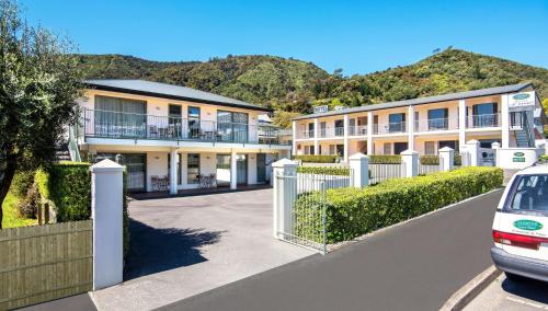 a row of apartment buildings with a fence at Jasmine Court Motel in Picton