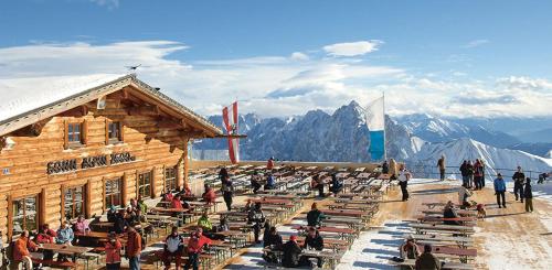 a group of people sitting outside of a building on a mountain at Am-Berg Ferienwohnung in Bad kohlgrub in Bad Kohlgrub