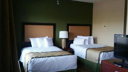 a hotel room with two beds and a television at Extended Stay America Suites - Albuquerque - Rio Rancho Blvd in Rio Rancho