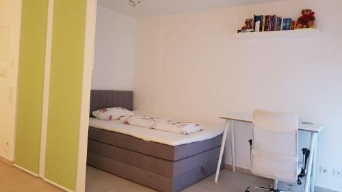 ein kleines Schlafzimmer mit einem Bett und einem Schreibtisch in der Unterkunft Schicke Ferienwohnung Darmstadt Bessungen in Darmstadt