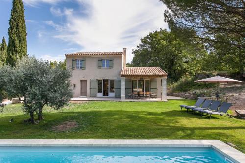 une maison avec une piscine en face d'une cour dans l'établissement Les Amandiers, à Bonnieux
