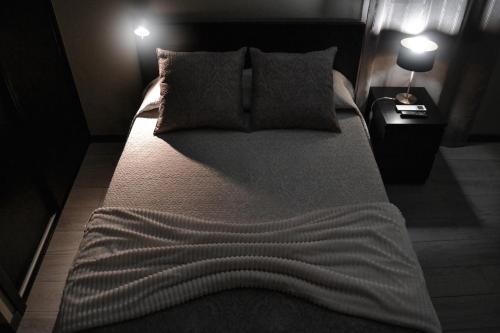 a bed with a blanket and two pillows on it at Anevan in Vidago
